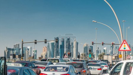 Téléchargez les photos : L'horizon de Doha et les embouteillages à l'intersection se succèdent depuis la corniche de Doha, au Qatar, au Moyen-Orient. Voitures devant les feux de circulation - en image libre de droit