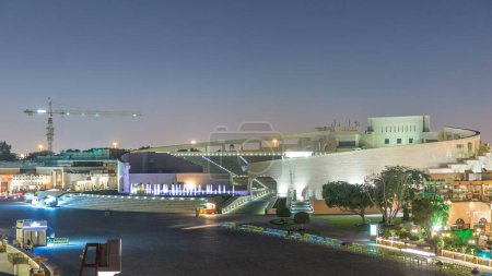 Photo for Illuminated amphitheater in Katara cultural village night timelapse, Doha Qatar. Aerial top view. People walking in front of fountain - Royalty Free Image