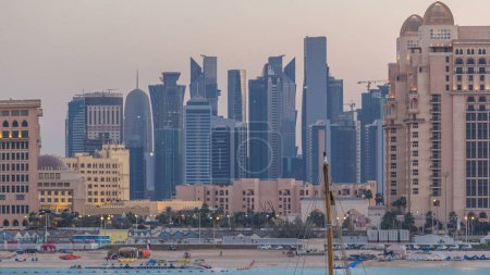 Foto de Vista desde Katara Beach día a noche timelapse transición después del atardecer en Doha, Qatar, hacia la Bahía Oeste y el centro de la ciudad. Rascacielos vista de cerca - Imagen libre de derechos