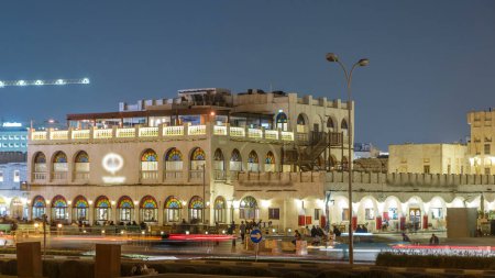 Téléchargez les photos : Souq Waqif nuit timelapse. C'est un marché populaire à Doha, au Qatar. Le souk est réputé pour vendre des vêtements traditionnels, des épices, de l'artisanat et des souvenirs. vue depuis le parc - en image libre de droit