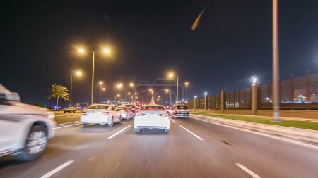 Téléchargez les photos : Conduisez dans la circulation sur la route de corniche et les rues du centre-ville à Doha timelapse hyperlapse drivelapse. Qatar, Moyen-Orient - en image libre de droit