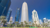 The skyline of Doha seen from Park timelapse hyperlapse, Qatar. Trees and palms on foreground. Modern skyscrapers and towers on background. Traffic on road puzzle #707668748