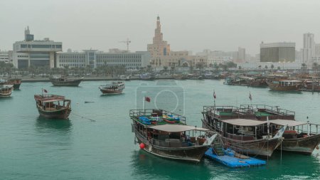 Téléchargez les photos : Soirée à Doha Bay période de transition de jour à la nuit avec des bateaux de pêche traditionnels boutre en bois. Vue du musée avec Corniche, Doha, Qatar - en image libre de droit
