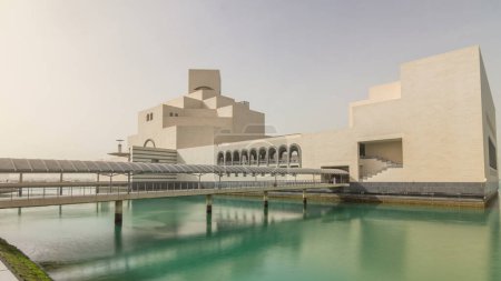 Téléchargez les photos : Musée d'art islamique du Qatar hyperlapsus timelapse sur son île artificielle à côté de Doha Corniche, avec des boutres amarrées dans la baie qui l'entoure - en image libre de droit