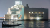 Beautiful Museum of Islamic Art illuminated at night timelapse in Doha, Qatar. Boats and reflection on water of Gulf. It is one of the worlds most complete collections of Islamic artifacts mug #707669860