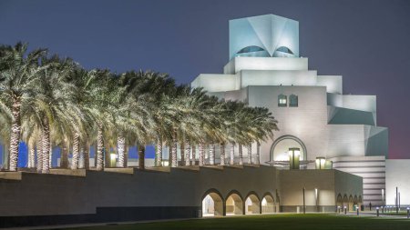 Téléchargez les photos : Musée d'Art Islamique illuminé la nuit avec fontaine timelapse à Doha, Qatar. Les paumes sur le côté. Vue depuis le parc MIA. C'est l'une des collections d'artefacts islamiques les plus complètes au monde. - en image libre de droit