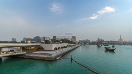 Téléchargez les photos : Vue sur la ville de Doha en face du parc du Musée d'Art Islamique, de jour comme de nuit, dans la capitale qatarie, Doha. Bateaux et pont - en image libre de droit
