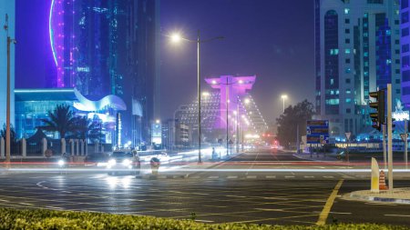 Foto de Doha West Bay vista cerca del hotel parque nocturno timelapse, Doha, Qatar, Oriente Medio. Tráfico en el cruce. Clima brumoso - Imagen libre de derechos