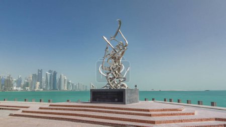 Foto de Escultura caligráfica en la Corniche de Doha timelapse hyperlapse, Qatar. Rascacielos de la bahía oeste en el fondo - Imagen libre de derechos