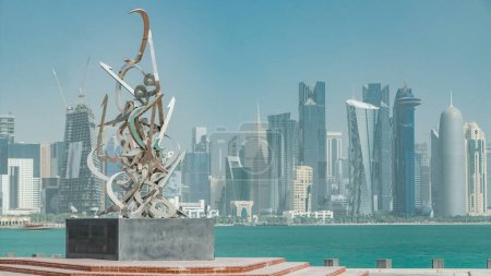 Téléchargez les photos : Calligraphie sculpture sur la Corniche de Doha timelapse, Qatar. Gratte-ciel de baie ouest sur fond - en image libre de droit