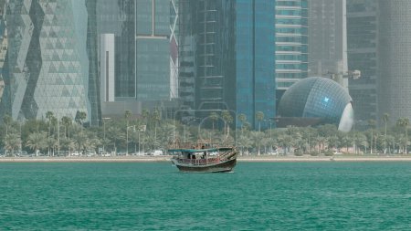 A dhow going to harbour in Doha timelapse, Qatar, with the city's modern skyline in the background at sunny day puzzle 707670472