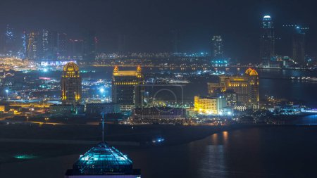 Téléchargez les photos : Vue aérienne de nuit vers Pearl-Qatar timelapse depuis le sommet. C'est une île artificielle au Qatar. Vue de la Marina et des bâtiments résidentiels à Doha, Qatar, Moyen-Orient - en image libre de droit