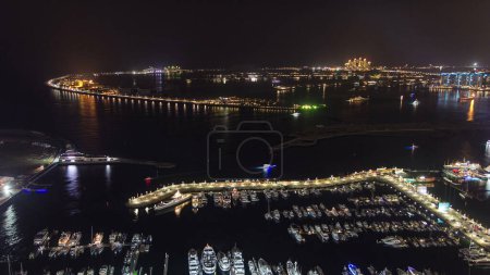 Téléchargez les photos : Vue aérienne de Dubai Marina panorama timelapse à île de palmier jumeirah. Vue de dessus avec des hôtels et villas éclairés. Yachts et bateaux dans le port - en image libre de droit
