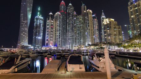 Photo for Dubai Marina with block of tallest skyscrapers residential towers and boats in harbor night timelapse hyperlapse in Dubai, United Arab Emirates - Royalty Free Image