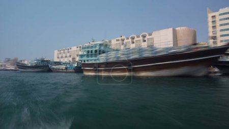 Téléchargez les photos : Vue depuis le bateau Abra traditionnel au ruisseau Deira à Dubaï, hyperlapsus timelapse des EAU. Le transport le moins cher. Bâtiments sur un front de mer. Mouvement flou - en image libre de droit