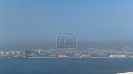 Téléchargez les photos : Vue dégagée sur l'île artificielle Palm Jumeirah depuis Burj Al Arab le matin à Dubaï, Émirats arabes unis. C'est l'une des trois îles appelées les îles Palm sur la côte de Dubaï. timelapse - en image libre de droit