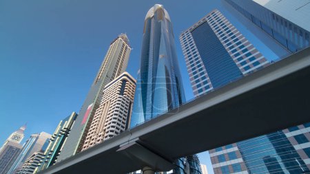 Téléchargez les photos : Les gratte-ciel de la Sheikh Zayed Road avec ligne de métro à Dubaï intemporel hyperlapsus au coucher du soleil. Regardez vers le haut - en image libre de droit