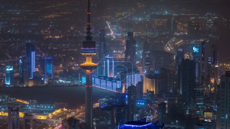 Foto de Vista superior de la Torre de Liberación timelapse en la ciudad de Kuwait iluminado por la noche con el tráfico en la carretera y el horizonte de la ciudad. Kuwait, Oriente Medio - Imagen libre de derechos