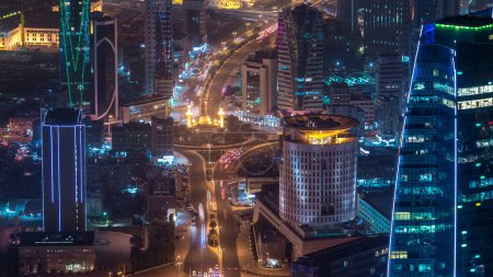 Photo for Skyline with Skyscrapers night timelapse in Kuwait City downtown illuminated at dusk. Aerial view from rooftop. Kuwait City, Middle East. - Royalty Free Image