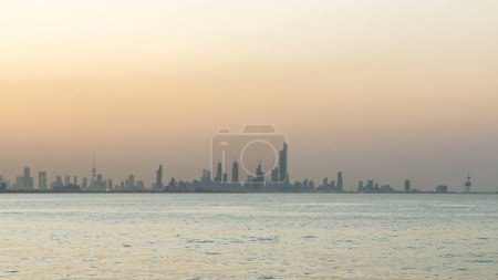Téléchargez les photos : Skyline avec gratte-ciel jour à nuit transition timelapse dans le centre-ville de Koweït illuminé au crépuscule. Vue du centre scientifique avec réflexion sur l'eau. Koweït, Moyen-Orient. - en image libre de droit