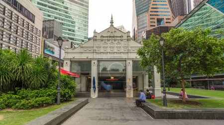 Téléchargez les photos : Sortie de la station de métro et des gratte-ciel à Raffles Place à Singapour Financial Centre timelapse hyperlapse. Pelouse verte. Des gens qui marchent - en image libre de droit