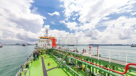 Photo for Green deck of the tanker under cloudy sky timelapse. Crane with pipe moving on it by operator. Panoramic view - Royalty Free Image