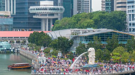 Photo for Aerial view of central Singapore. Merlion fountain sculpture with financial towers on background timelapse. People walking around - Royalty Free Image