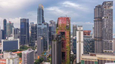 Téléchargez les photos : Vue aérienne du centre-ville de Singapour, du jour à la nuit, période de transition depuis le toit. Tours et gratte-ciel modernes illuminés le soir - en image libre de droit