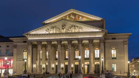 Teatro Nacional de Múnich o Teatro Nacional en la plaza Max Joseph día a noche timelapse transición. Histórico teatro de ópera, sede de la Ópera Estatal de Baviera. Iluminación nocturna después de la puesta del sol. Alemania