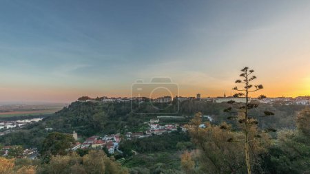 Panorama montrant le coucher du soleil sur le château d'Almourol sur la colline de Santarem timelapse aérien. Un château médiéval au sommet de l'îlot d'Almourol au milieu du Tage et des maisons. Portugal