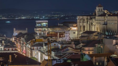 Lisbon from above night timelapse: view of illuminated Baixa district with Santa Justa Lift, also called Carmo Lift and Convento da Ordem do Carmo, historical church. View from above. Portugal