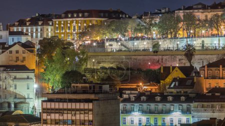 Foto de Vista aérea sobre el centro de Lisboa hasta el mirador llamado: Miradouro de Sao Pedro de Alcántara noche timelapse. Gloria Funicular subiendo y bajando. Gente en el parque. Portugal - Imagen libre de derechos