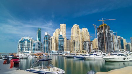 Foto de Vista sobre Dubai Marina desde el muelle con yates. Hiperlapso de tiempo de la ciudad de negocios en Dubai en el paseo marítimo, Emiratos Árabes Unidos - Imagen libre de derechos