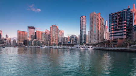Téléchargez les photos : Dubai Marina panorama avec tours et yacht club du front de mer à Dubaï de jour à la nuit transition timelapse, Émirats arabes unis. Quartier de Dubaï et un canal artificiel après le coucher du soleil - en image libre de droit