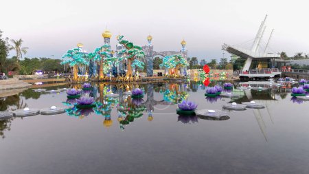 Lake with flowers and castle in Dubai Glow Garden night. It is a state of Art architecture featuring environment friendly architecture, creating various structures from the recyclable products.