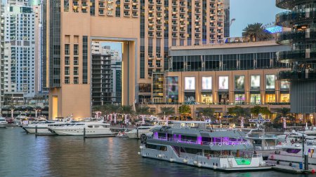 Téléchargez les photos : Dubai Marina front de mer avec des yachts et des tours modernes près du centre commercial du pont à Dubaï transition de jour à la nuit, Émirats arabes unis. Dubai Marina est un quartier de Dubaï et un canal artificiel - en image libre de droit