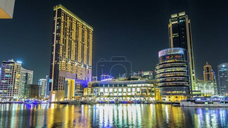 Foto de Paseo marítimo de Dubai Marina con yates y modernas torres con restaurantes del puente nocturno timelapse hyperlapse, Emiratos Árabes Unidos. Centro comercial y cafeterías - Imagen libre de derechos