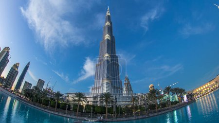 Foto de Burj Khalifa fachada día a noche transición timelapse ojo de pez en Dubai, Emiratos Árabes Unidos. Las luces se encienden. Burj Khalifa es un edificio más alto del mundo. Situado en el centro de Dubai, Sheikh Zayed Road. - Imagen libre de derechos