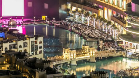 Téléchargez les photos : Top vue rapprochée du pont sur le lac artificiel avec spectacle de fontaine de musique près du centre commercial timelapse dans le centre-ville de Dubaï avant la célébration du nouvel an, Émirats arabes unis. - en image libre de droit