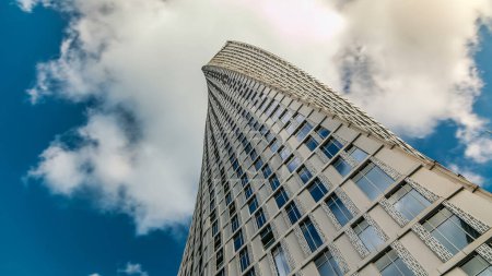 Photo for Cayan Tower (known also as Infinity Tower) in Dubai Marina. Perspective look up view from bottom to cloudy blue sky, The tower is world's tallest high rise building with a twist of 90 degrees - Royalty Free Image