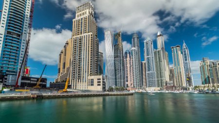 Foto de Dubai Marina canal con yates y modernas torres reflejadas en el agua verde de la costa en Dubai timelapse hyperlapse, Emiratos Árabes Unidos. Canal artificial y rascacielos alrededor - Imagen libre de derechos