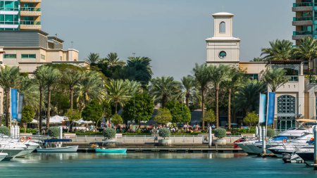 Téléchargez les photos : Fontaine et palmiers timelapse à la marina promenade avec des yachts flottants et des bateaux, Pendant la journée. Dubai, Émirats arabes unis - en image libre de droit