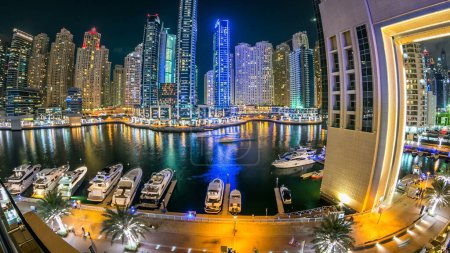 Téléchargez les photos : Dubai Marina promenade panorama, yachts avec tours autour du canal depuis le centre commercial balcon à Dubai nuit timelapse, Émirats arabes unis. - en image libre de droit