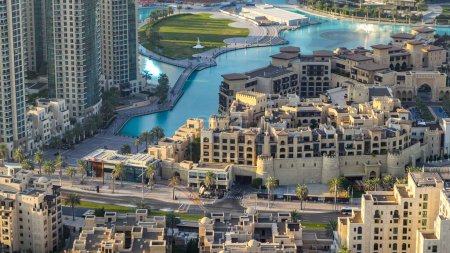 Top Nahaufnahme der Brücke über den künstlichen See und einige Menschen, die im Park mit Handdenkmal-Zeitraffer in Dubai Downtown vor Sonnenuntergang, Vereinigte Arabische Emirate, spazieren gehen. Es befindet sich in der Innenstadt