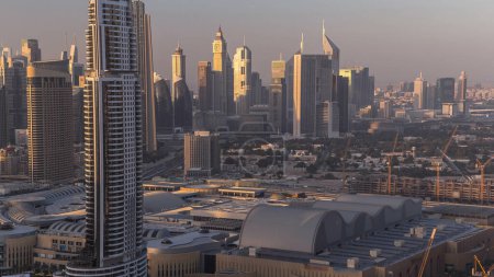 Foto de Dubai horizonte del centro día a la noche de transición aérea timelapse. Vista superior de la carretera Sheikh Zayed con numerosas torres iluminadas y rascacielos. Tráfico en la carretera. Monumento famoso - Imagen libre de derechos