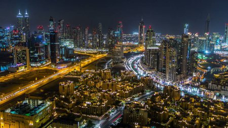 Photo for Aerial view of a big modern city at night timelapse with night traffic and illuminated skyscrapers, office buildings. Business bay, Dubai, United Arab Emirates. - Royalty Free Image