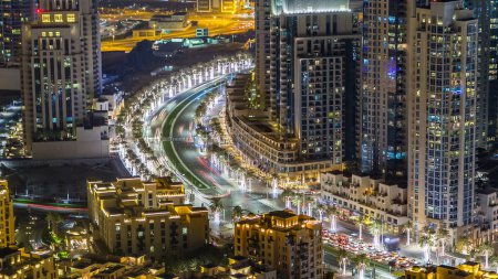 Téléchargez les photos : Vue de dessus de l'intersection de la route dans le centre-ville de Dubaï timelapse aérien avec la circulation nocturne, ligne de métro et gratte-ciel éclairés. C'est l'une des vues emblématiques de Dubaï, Émirats arabes unis - en image libre de droit