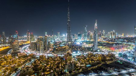 Téléchargez les photos : Dubaï Temps de la nuit au centre-ville avec Burj Khalifa et d'autres tours vue panoramique depuis le sommet à Dubaï, Émirats arabes unis. Circulation sur la route circulaire et spectacle de fontaine de musique - en image libre de droit