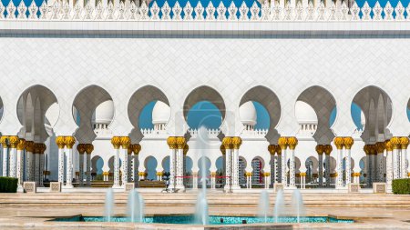 Photo for Fountain at Sheikh Zayed Grand Mosque timelapse located in Abu Dhabi - capital city of United Arab Emirates. It is largest mosque in UAE. Blue cloudy sky - Royalty Free Image