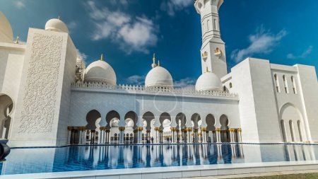 Téléchargez les photos : Piscine avec eau à la Grande Mosquée Cheikh Zayed hyperlapse timelapse situé à Abu Dhabi capitale des Émirats arabes unis. C'est la plus grande mosquée des EAU. Ciel nuageux bleu - en image libre de droit